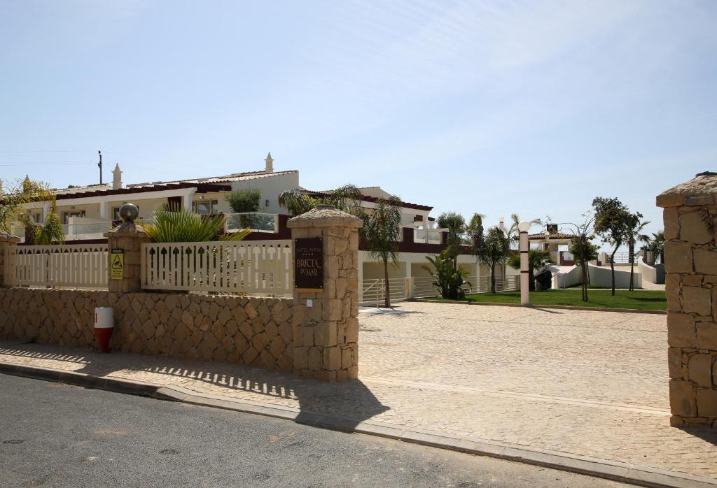 a stone fence in front of a house at Hotel Rural Brícia Du Mar in Ferragudo