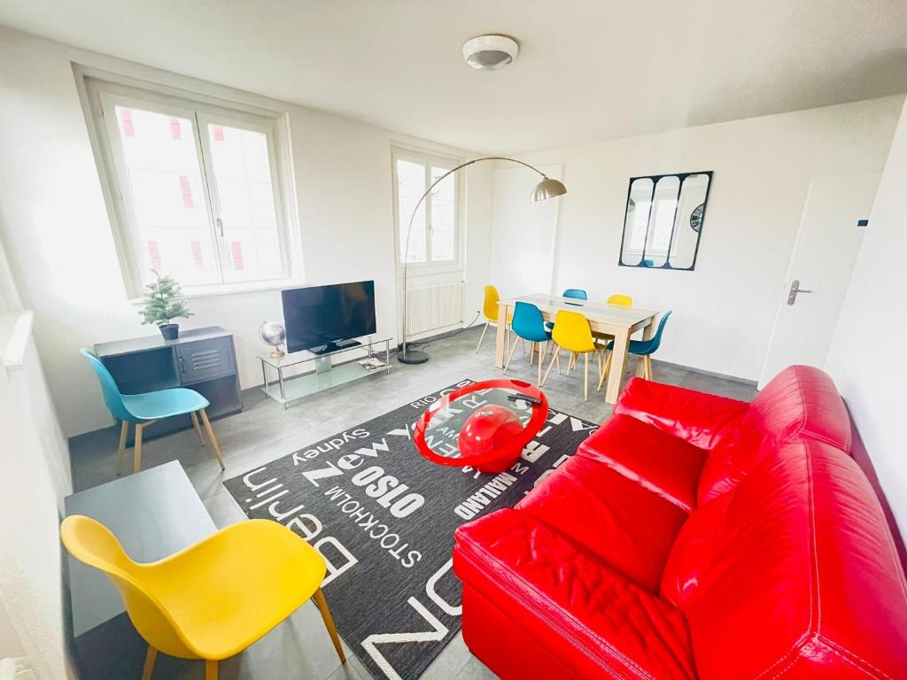 ein Wohnzimmer mit einem roten Sofa und Stühlen in der Unterkunft The 5 continents III by Stay Swiss in Pruntrut