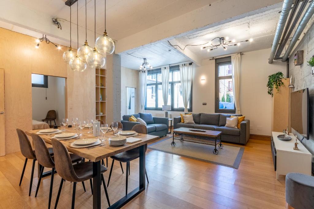 a dining room and living room with a table and chairs at NEW! Lovely 3-Bedroom Loft in Bilbao in Bilbao