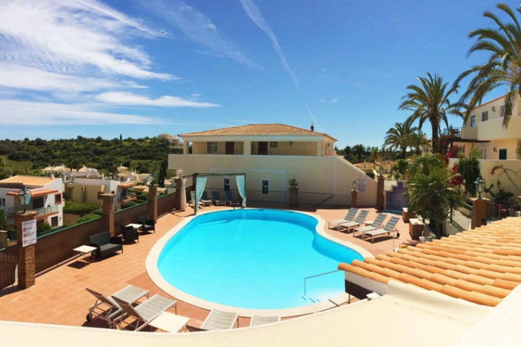 a villa with a swimming pool in front of a house at 2BR Duplex Townhouse with access to Pool - 5mn to Beach by LovelyStay in Ferragudo