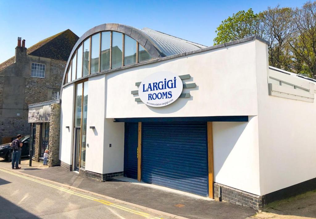 een groot wit gebouw met een garagelords bord erop bij Largigi, Free Parking, Close to the Beach and Town Centre Rooms in Lyme Regis