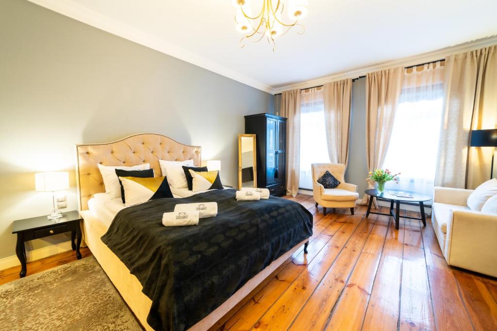 a bedroom with a large bed and a living room at Apartamenty Pod Zegarem in Mikołajki