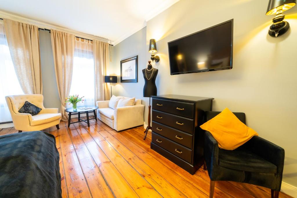 Televízia a/alebo spoločenská miestnosť v ubytovaní Apartamenty Pod Zegarem
