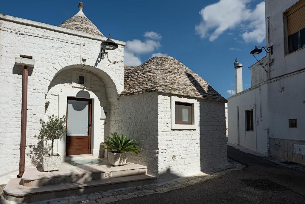 un piccolo edificio in mattoni bianchi con una porta di Trulli Quercus ad Alberobello