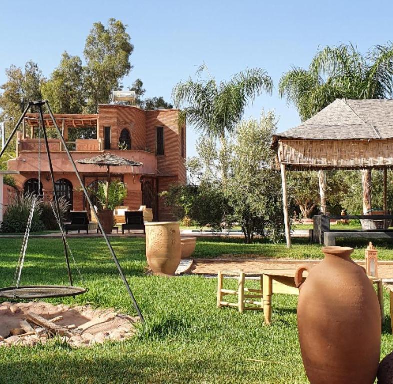 une cour avec une aire de jeux et une maison dans l'établissement RIAD - Jnan Bnati - Pool, à Marrakech