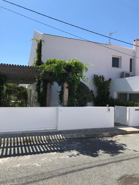 a white fence in front of a white house at Casa da Mondina Comporta in Comporta