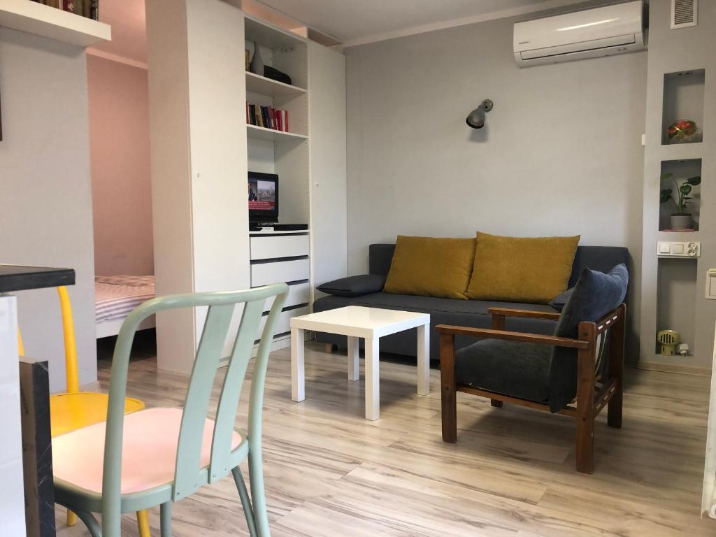 ein Wohnzimmer mit einem Sofa, einem Tisch und Stühlen in der Unterkunft Apartament Sikornik in Gliwice