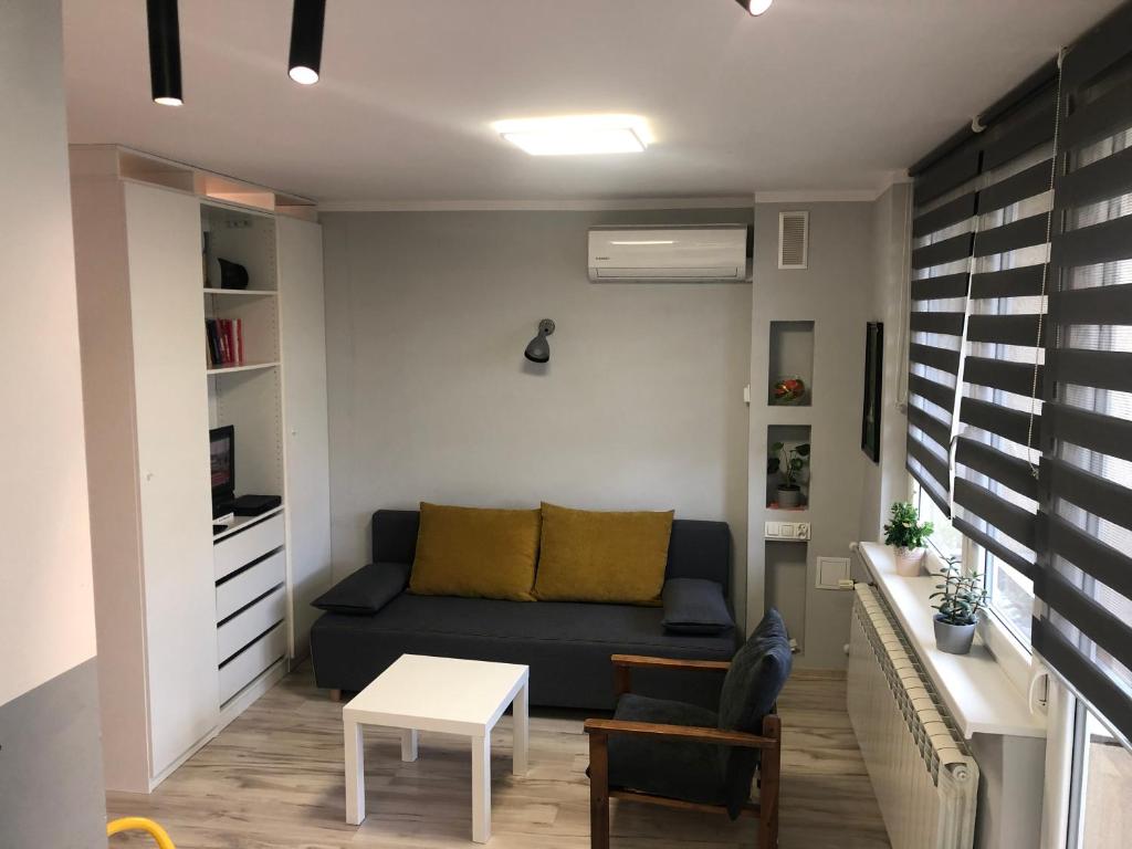 a living room with a couch and a table at Apartament Sikornik in Gliwice