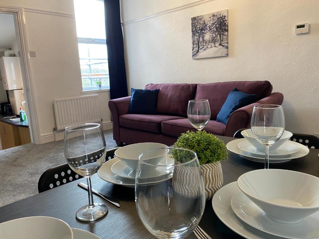 una mesa con platos y copas de vino encima en Rawling - Canny 2 bed flat close to Ncle free wifi & parking en Gateshead
