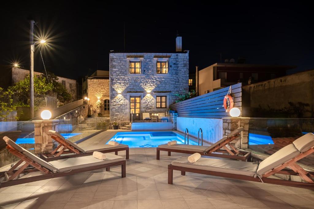 a house with a swimming pool at night at Alexandros Villa in Skouloúfia