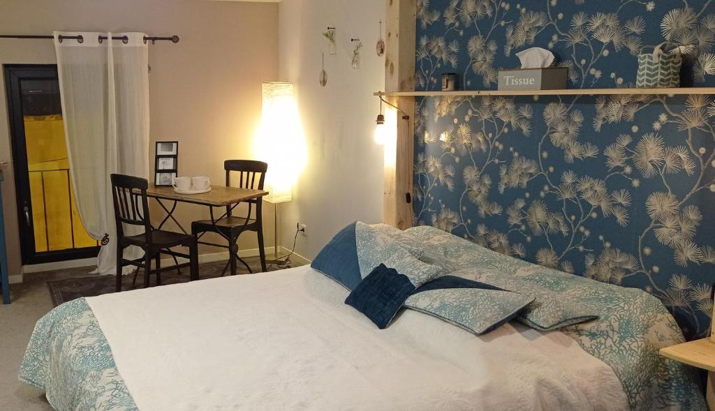 a bedroom with a bed with a blue patterned wall at Les chambres du magnolia in Canet