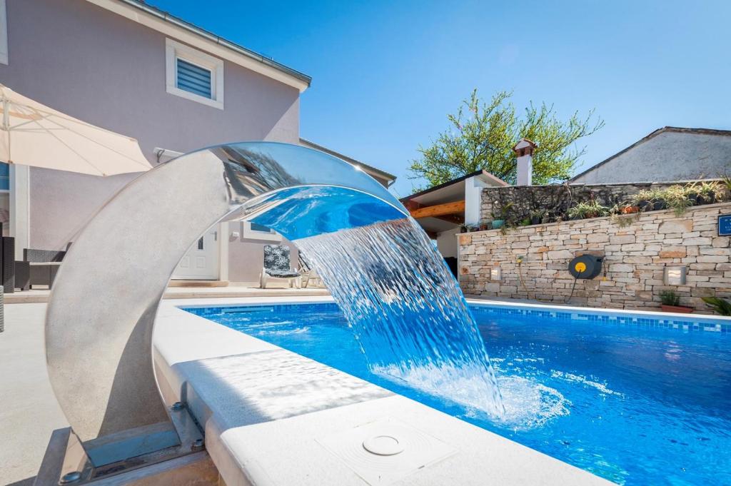 fontanna wodna przed basenem w obiekcie Holiday Home Fradelani w mieście Žminj