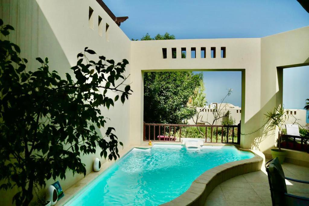 ein Schwimmbad in der Mitte eines Hauses in der Unterkunft Private guest house in five stars resort in Ras al Khaimah