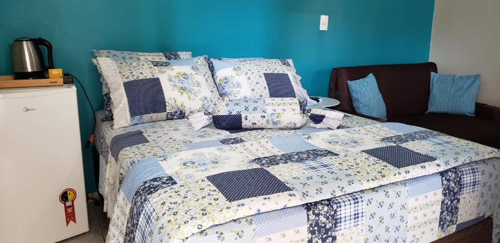 een slaapkamer met een bed met een quilt bij Suítes Ambiente Familiar -Prox do Thermas in Águas de São Pedro