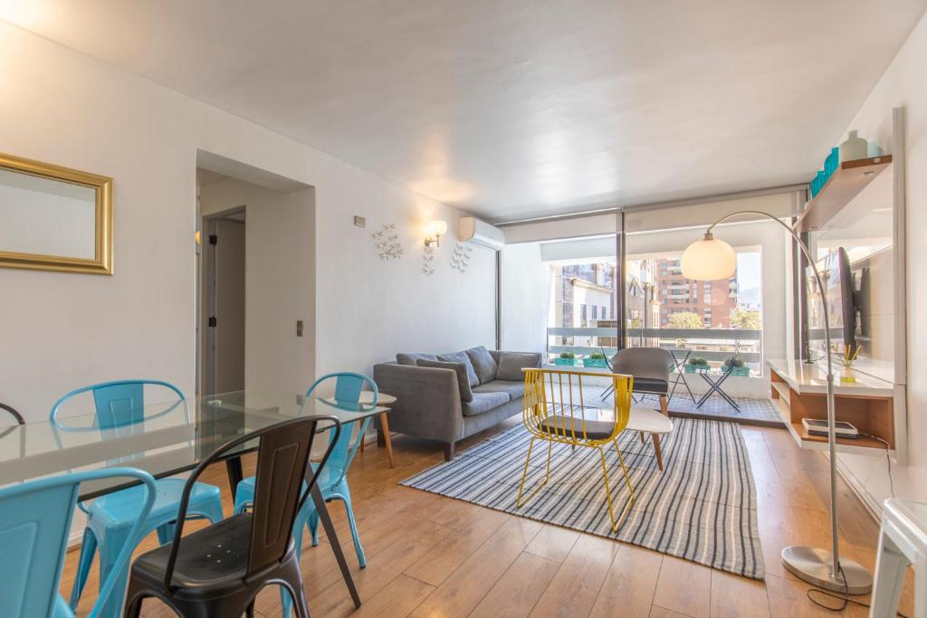 ein Wohnzimmer mit einem Glastisch und Stühlen in der Unterkunft Apartment - El Golf - Costanera Center in Santiago