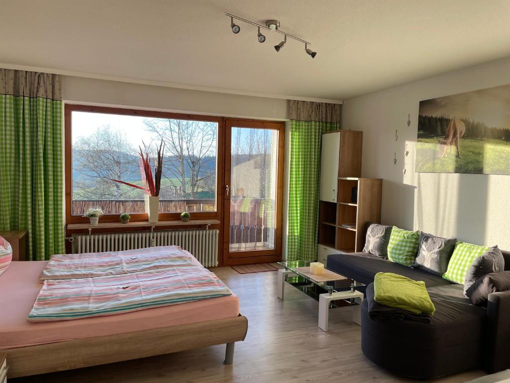 een woonkamer met een bed en een bank bij Fewo Ferienpark mit Swimmingpool und Aussicht 15 in Missen-Wilhams