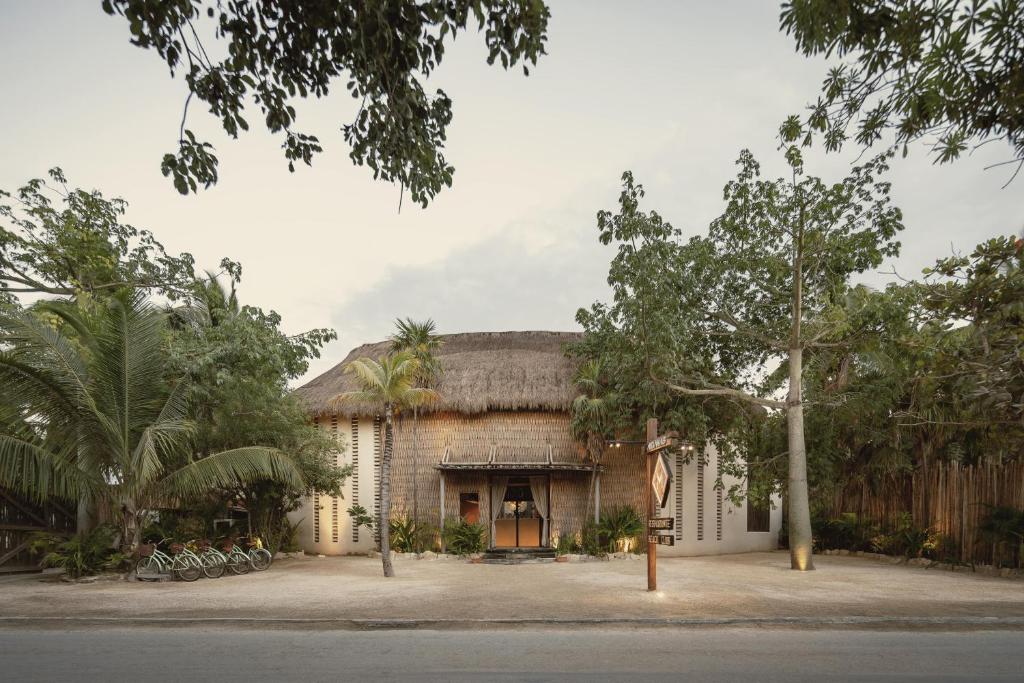 a large brick building with a thatched roof at Hotel Ma'xanab Tulum in Tulum