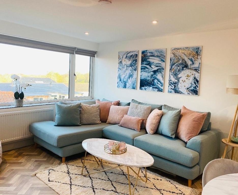sala de estar con sofá azul y mesa en Lees Lookout Holt ,2 bedroom luxury apartment with private parking en Holt