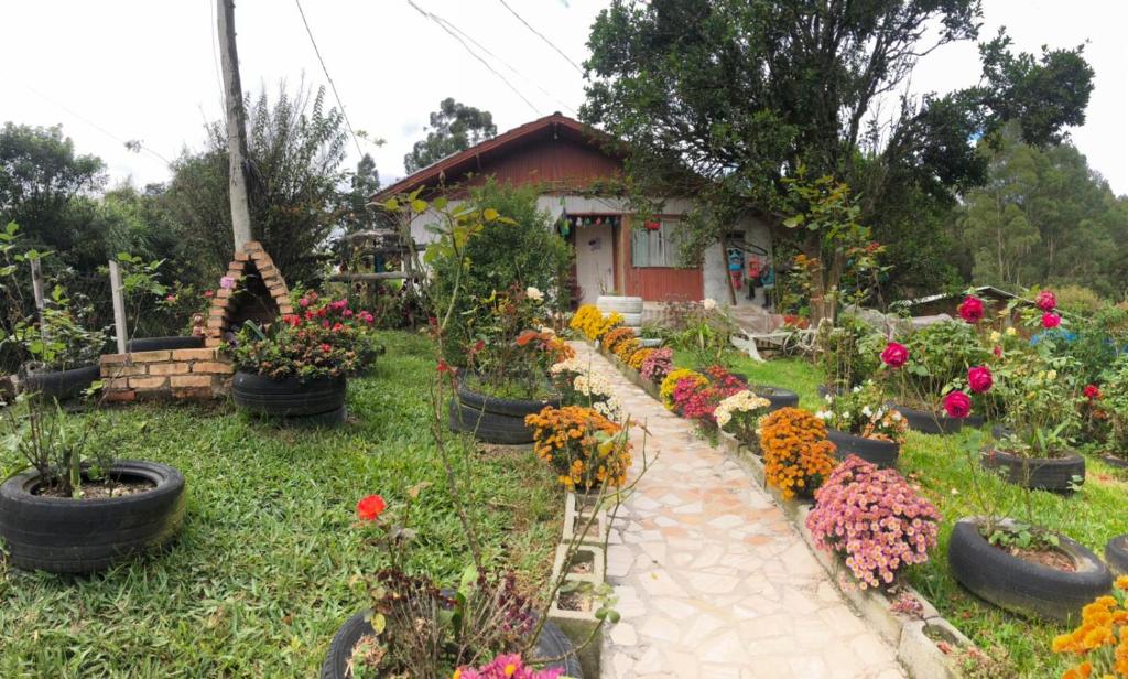 un jardín con muchas flores y una casa en Vovo Bebel, en Urubici