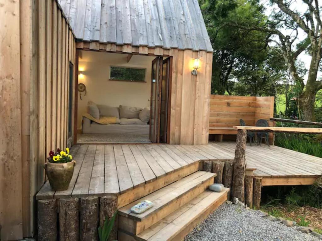 Cabaña de madera con banco en la cubierta en Lough Hyne Cottage en Skibbereen