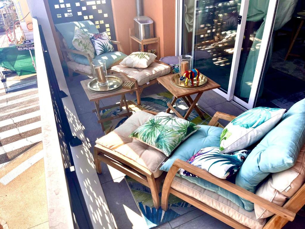 un porche con sofás y una mesa con almohadas en appartement carqueiranne le port, en Carqueiranne