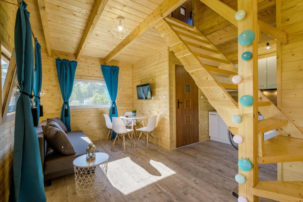 a large room with a staircase in a tiny house at Domek Piamola Kąty Rybackie in Kąty Rybackie