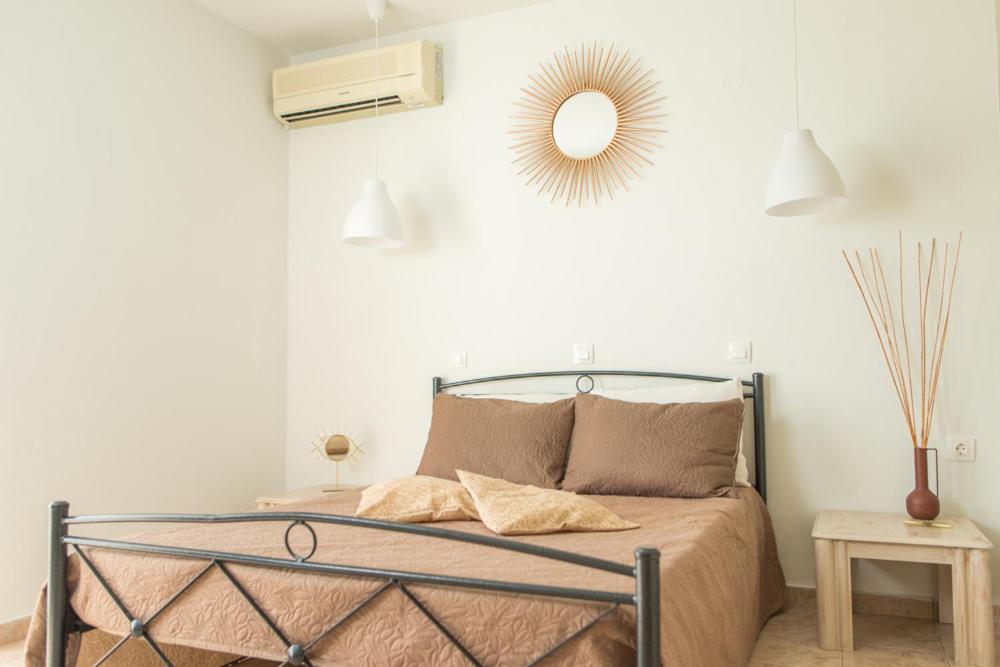 1 dormitorio con cama y espejo en la pared en Kampus living, en Faliraki