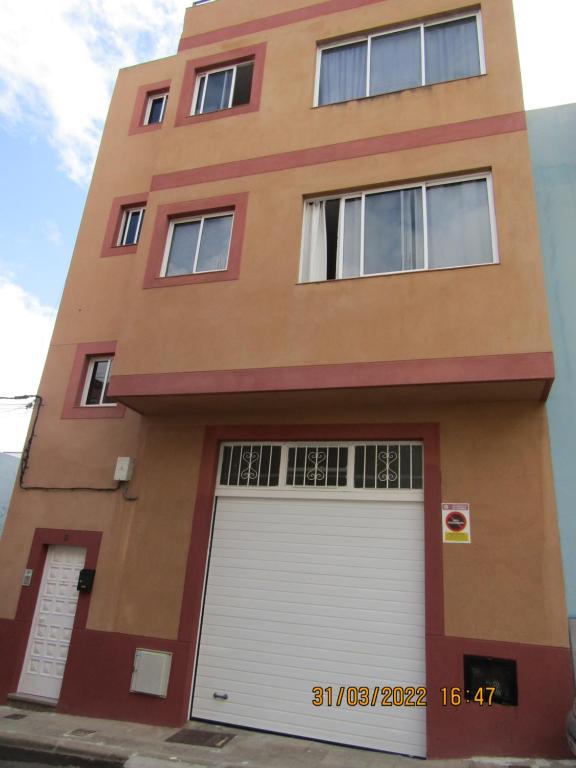 un edificio con una porta bianca per il garage di ACOGEDOR PISO EN SAN CRISTOBAL DE LA LAGUNA a La Laguna