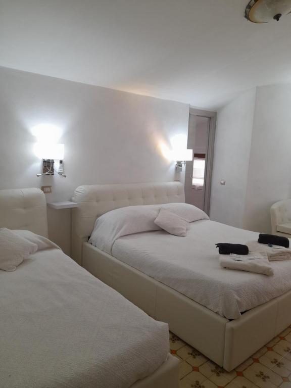 1 dormitorio con 2 camas y toallas. en B&B Camera & Caffe en Tempio Pausania