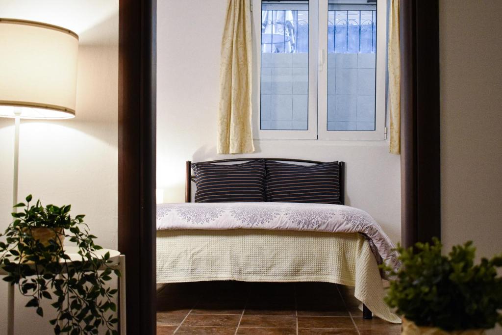 a bedroom with a bed and a window at At the core of the city next to Gallerius Palace in Thessaloniki