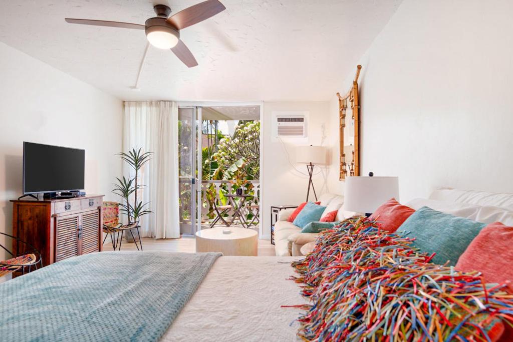 un soggiorno con letto e ventilatore a soffitto di Kona Islander Inn # 219 a Kailua-Kona