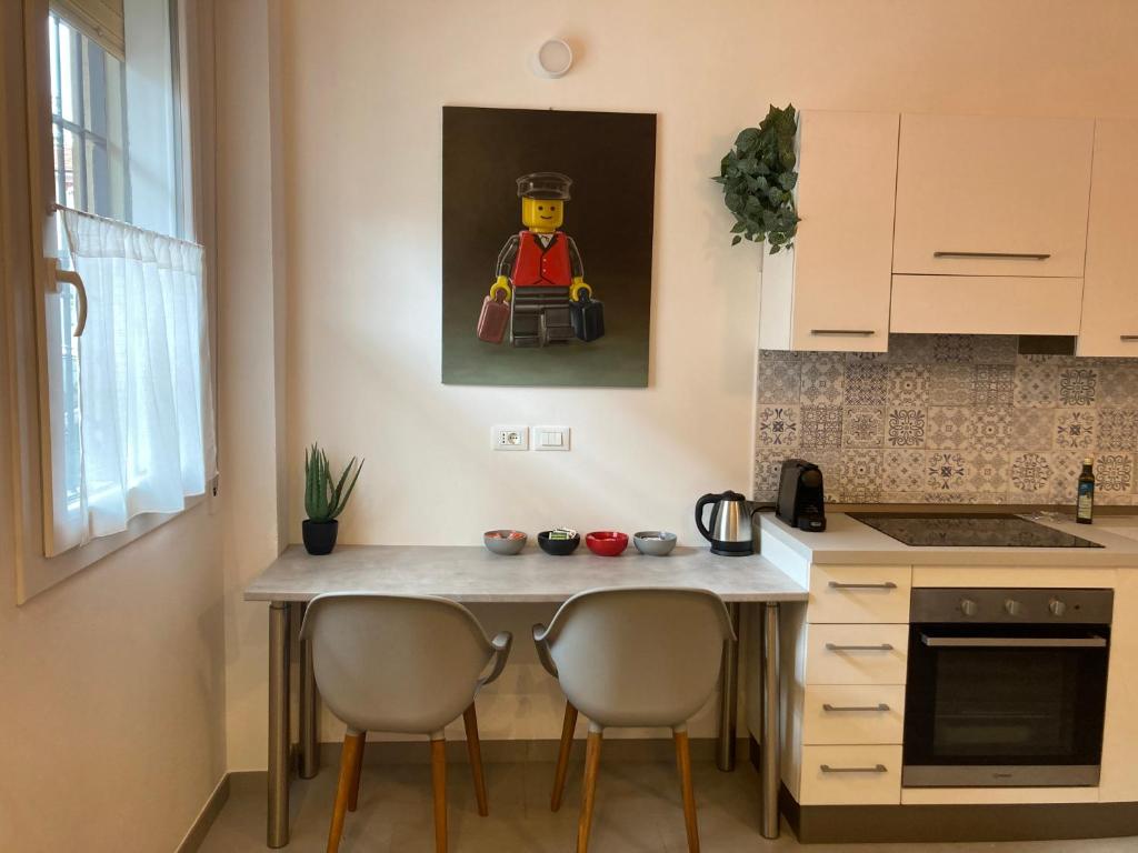 een keuken met een tafel met stoelen en een schilderij aan de muur bij Casa Cirenaica Art House in Bologna