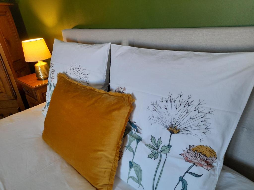 uma cama com duas almofadas com um padrão de flores em Villa Saint Léon em Badens