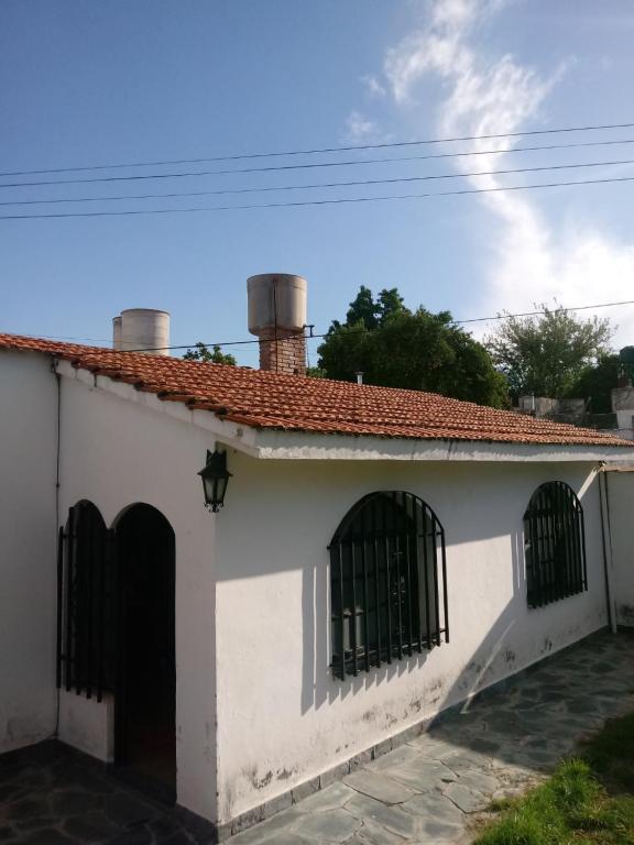 a white house with two windows and a roof at Hostel Alto Alberdi in Córdoba