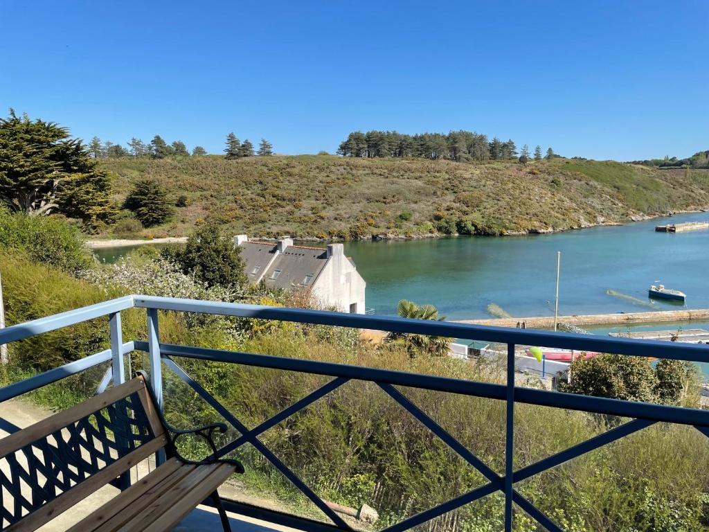 un banco sentado en un balcón con vistas al río en Appartement T3 vue mer Sauzon balcon et parking privé, en Sauzon