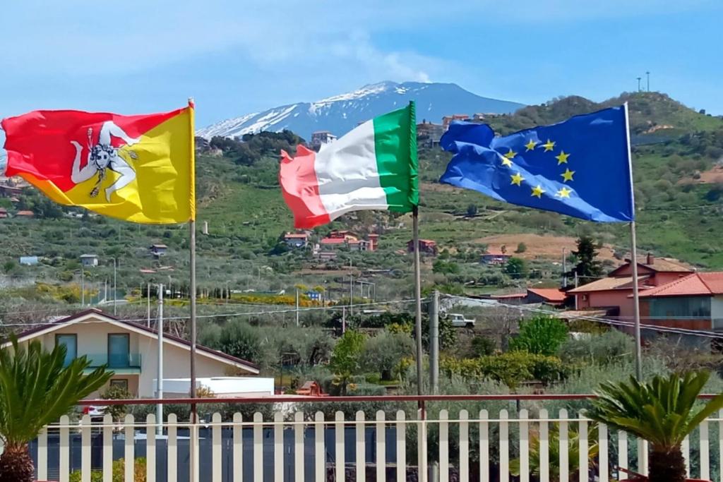 un grupo de banderas volando frente a una montaña en Azienda Agricola Cuntarati en Bronte