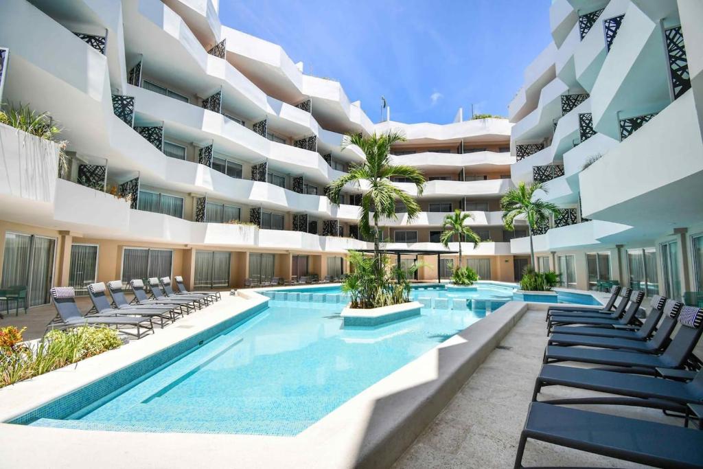 an exterior view of a building with a swimming pool at The Gallery Condos Playa de Carmen in Playa del Carmen