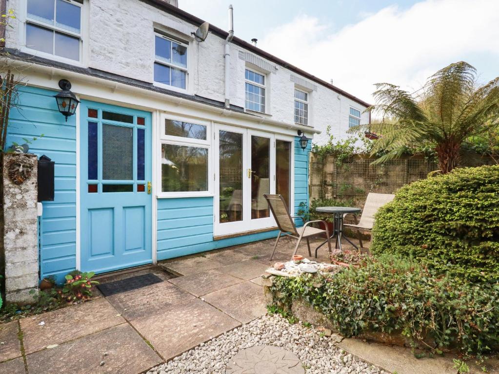 a house with a blue door and a patio at The Ark Cottage in Par