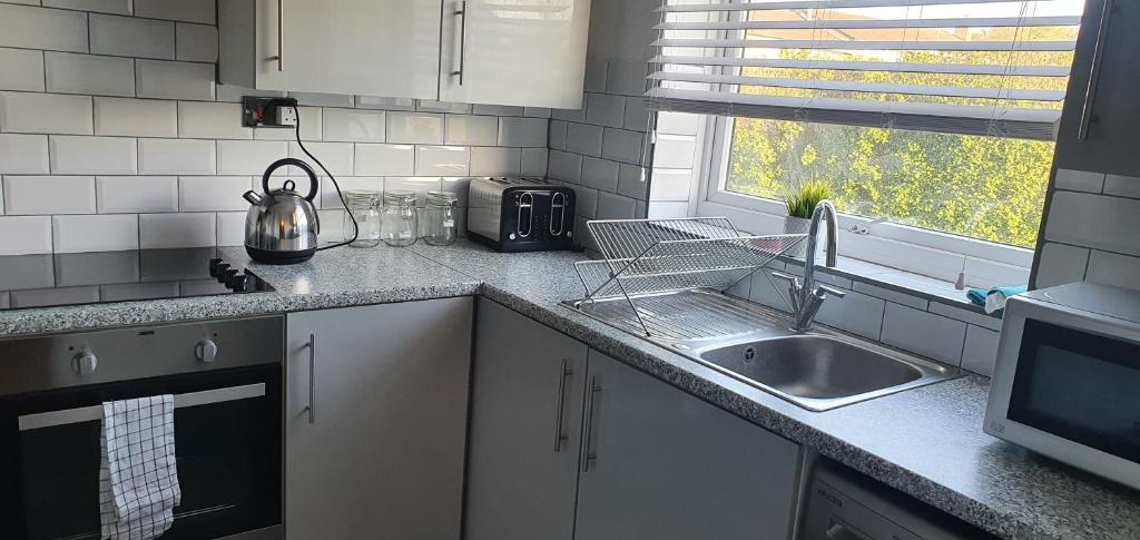 a kitchen counter with a sink and a microwave at The Court in Braintree