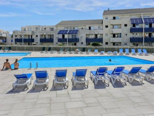 grupa niebiesko-białych krzeseł i basen w obiekcie Appartement Climatisé avec Piscine & Mer Bleu Marine w mieście Lacanau-Océan