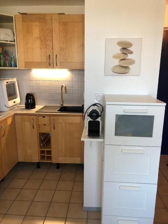Una cocina o kitchenette en Appartement Climatis&eacute; avec Piscine &amp; Mer Bleu Marine
