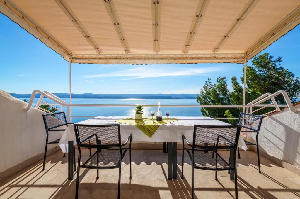 een tafel op een balkon met uitzicht op het water bij VILLA LEON*** in Mimice