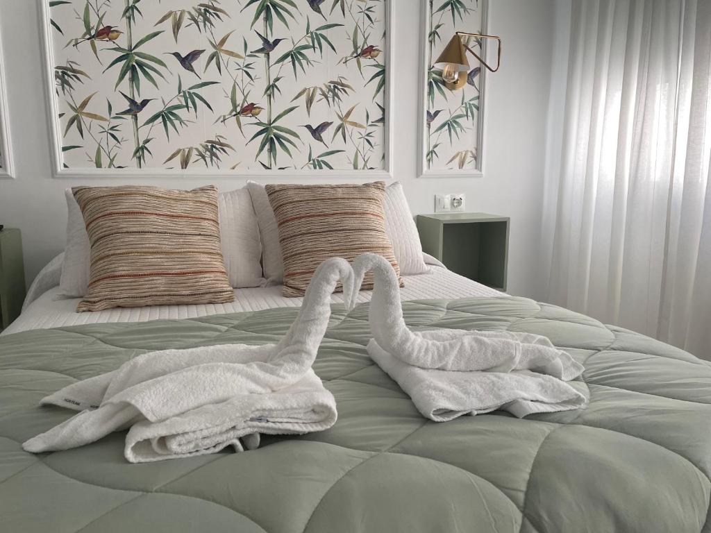 zwei Schwäne liegen auf einem Bett mit Handtüchern in der Unterkunft Apartamento La Luna de Villaceballos con PARKING GRATUITO in Córdoba