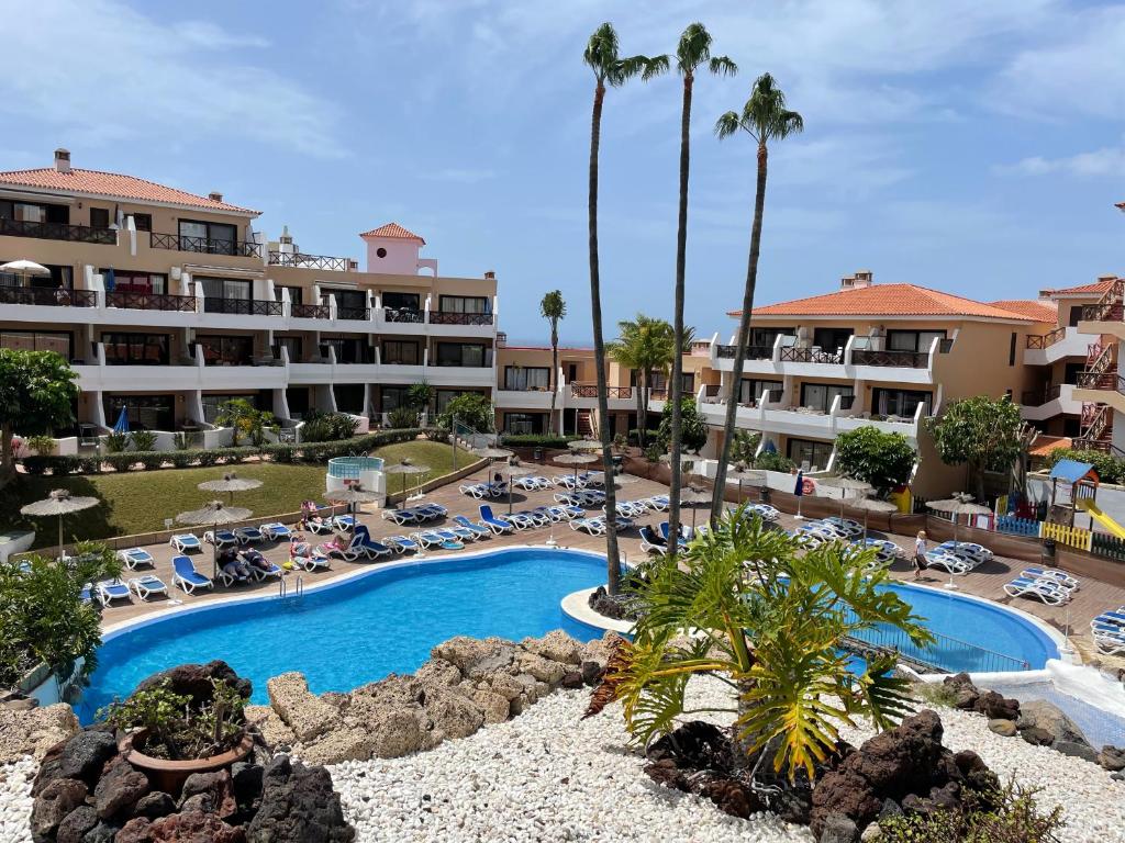 widok na ośrodek z basenem i palmami w obiekcie Tu hogar en Tenerife ,Parque Albatros w San Miguel de Abona