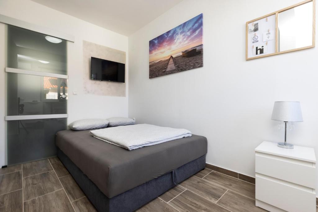 a bedroom with a bed and a tv on a wall at Studio Apartment PineTree - Mali Lošinj in Mali Lošinj