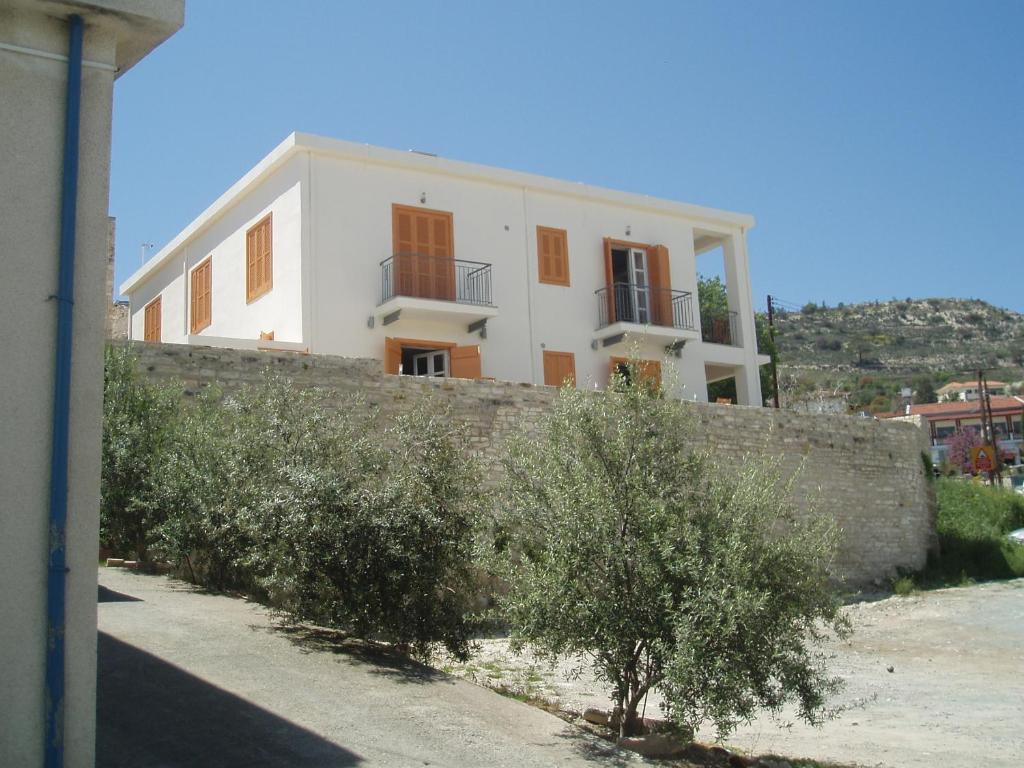 a white house with a wall and trees at Aunt Maria's in Pano Lefkara