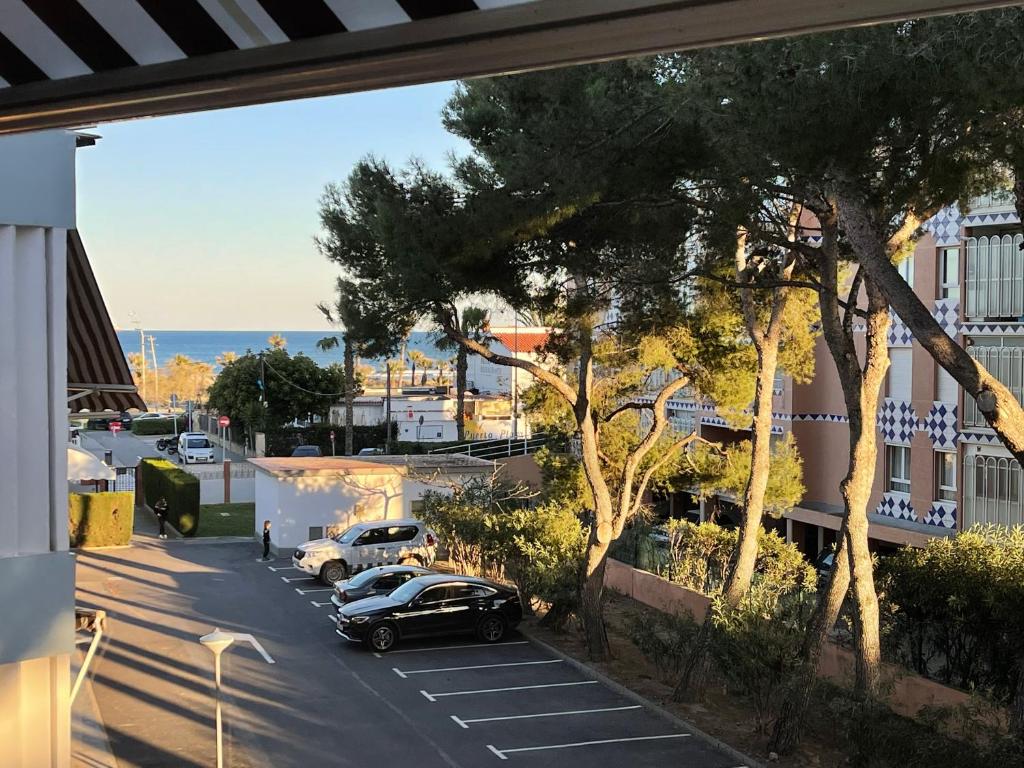 una vista de una calle con coches aparcados en un aparcamiento en Appartement ‘’Los Pinos’’ 50m de la plage en Grao de Castellón