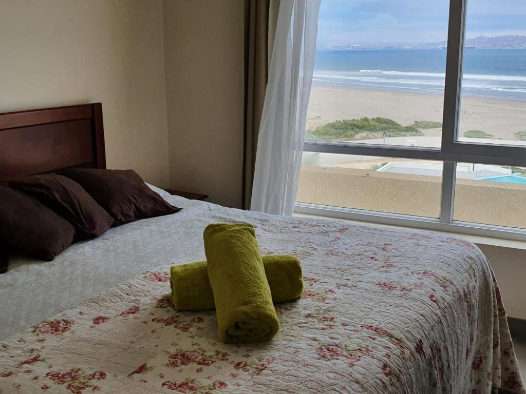 1 dormitorio con 1 cama y vistas a la playa en DEPARTAMENTO FRENTE AL MAR EN RESORT Laguna del Mar 7P, en La Serena