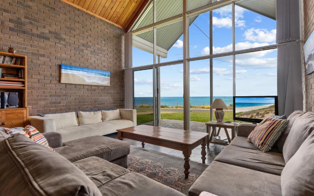ein Wohnzimmer mit 2 Sofas und einem großen Fenster in der Unterkunft South Beach House 2 11 Gold Coast Drive in Carrickalinga