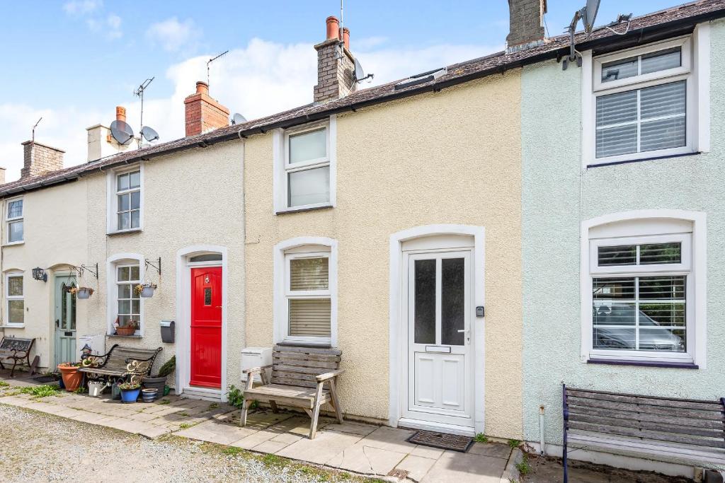 une rangée de maisons avec une porte rouge dans l'établissement Fishermans Cottage, à Conwy